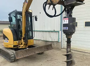 Compact excavator working with an auger attachment